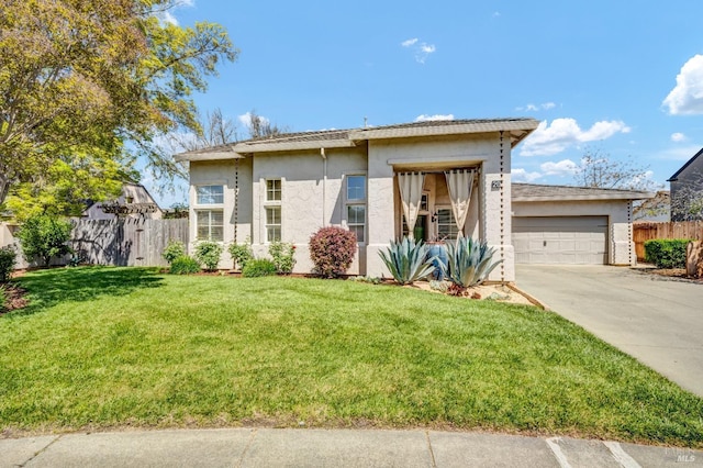 view of front of home with an attached garage, fence, concrete driveway, a front lawn, and stucco siding