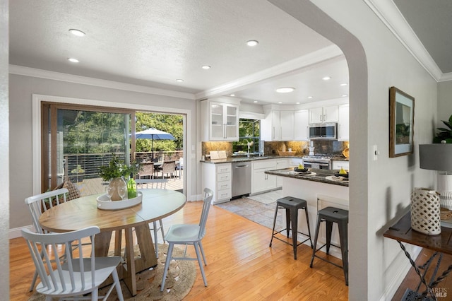 1036 Summit Ave, Napa, CA 94559 - kitchen with appliances with stainless steel finishes, ornamental molding, backsplash, dark countertops, and white cabinets