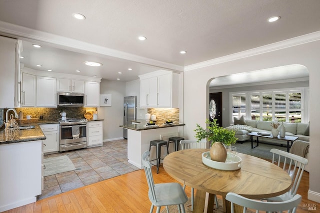 1036 Summit Ave, Napa, CA 94559 - dining space featuring arched walkways, recessed lighting, light wood-type flooring, and crown molding