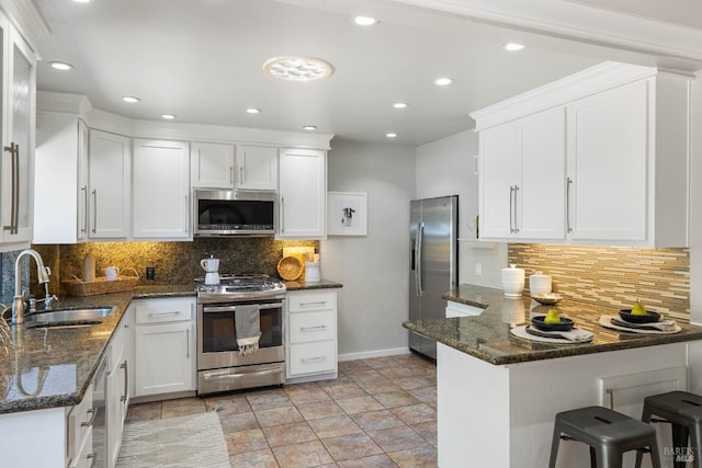 1036 Summit Ave, Napa, CA 94559 - kitchen featuring appliances with stainless steel finishes, a sink, baseboards, a peninsula, and white cabinetry