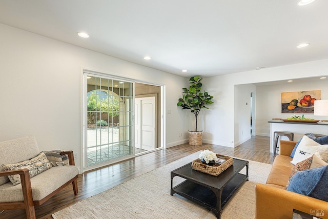 living area with wood finished floors, baseboards, and recessed lighting
