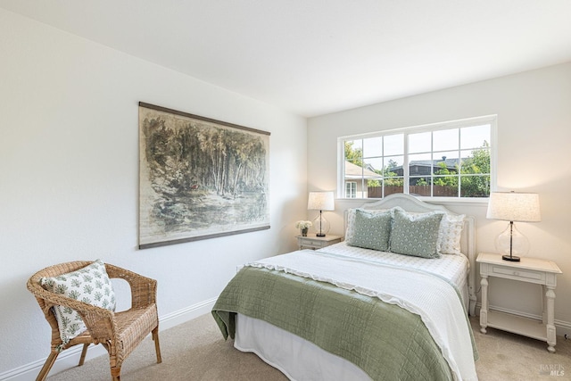bedroom with baseboards and light carpet