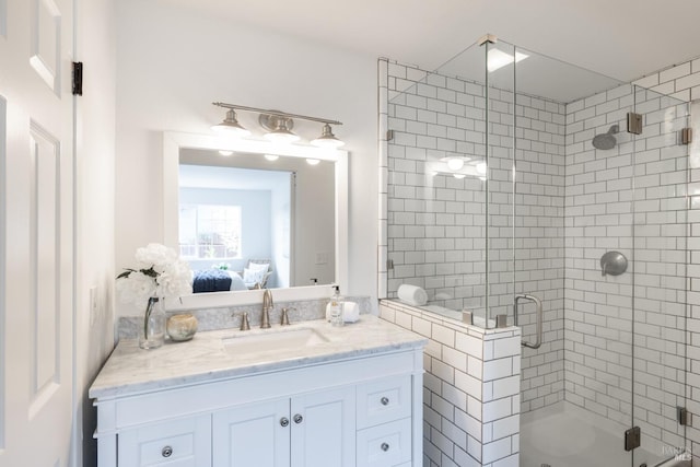 ensuite bathroom with tiled shower, ensuite bath, and vanity