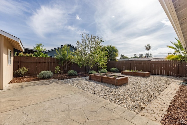 view of patio with a garden and fence