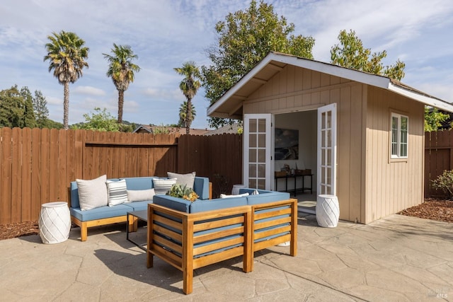 view of patio / terrace featuring a fenced backyard, outdoor lounge area, and an outdoor structure
