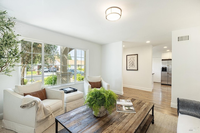 living room featuring recessed lighting, visible vents, baseboards, and light wood-style flooring