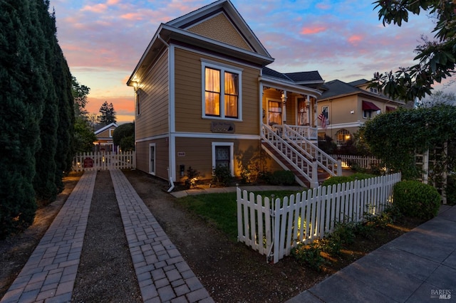 view of front of property featuring stairs and a fenced front yard