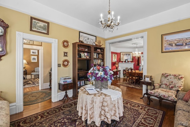 sitting room with wood finished floors and a notable chandelier