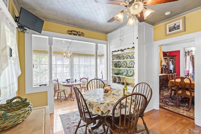 dining room with light wood finished floors and ceiling fan with notable chandelier