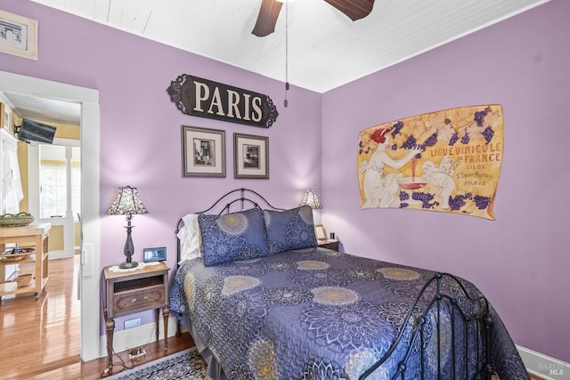 bedroom featuring baseboards, a ceiling fan, and wood finished floors