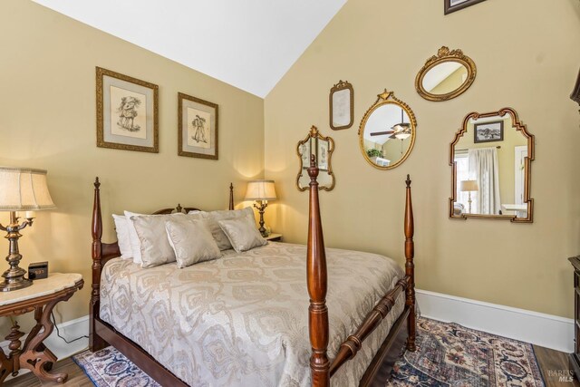 bedroom featuring baseboards, wood finished floors, and lofted ceiling