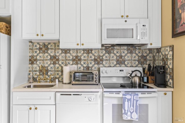 kitchen with a toaster, white appliances, light countertops, backsplash, and a sink