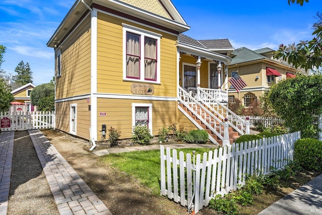 victorian home with stairs, a porch, and fence