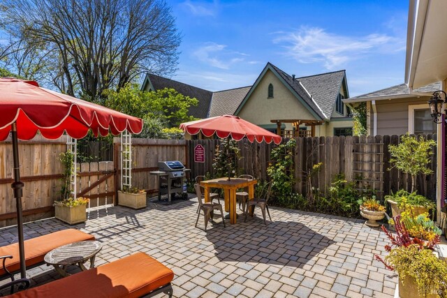 view of patio / terrace with area for grilling, outdoor dining area, fence private yard, and a gate