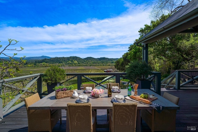 wooden terrace with a mountain view and outdoor dining area