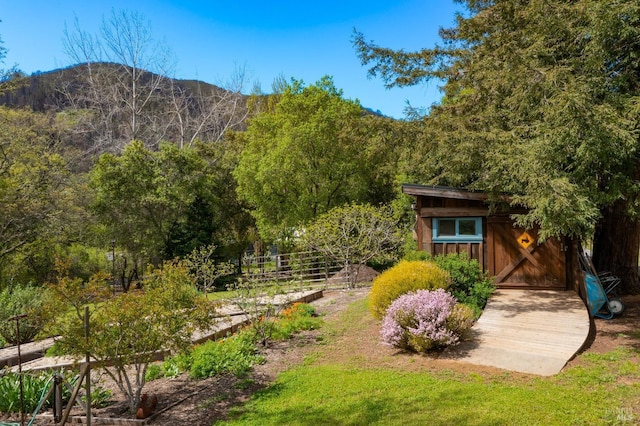 view of yard with an outbuilding, a mountain view, and a storage unit