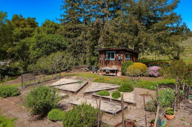 view of yard featuring a garden, an outbuilding, and central AC