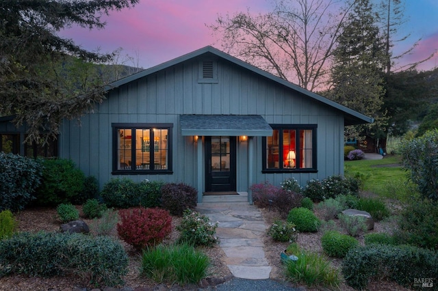 view of front of house with board and batten siding and a shingled roof