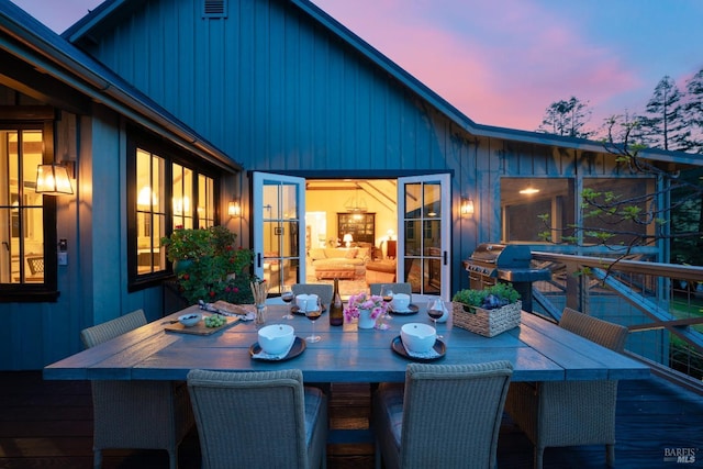 deck at dusk featuring outdoor dining space
