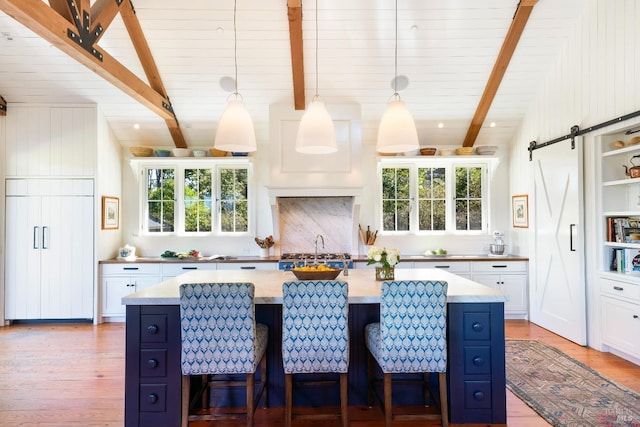 kitchen featuring light wood-type flooring, a sink, white cabinetry, and paneled built in refrigerator