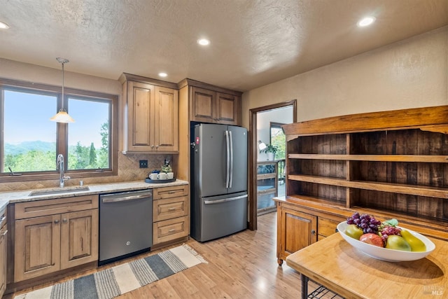 kitchen featuring recessed lighting, light wood-style floors, appliances with stainless steel finishes, and a sink