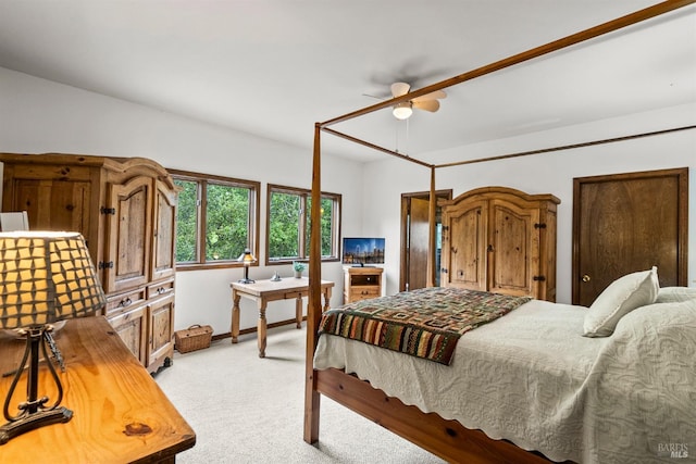 bedroom featuring light colored carpet, baseboards, and a ceiling fan