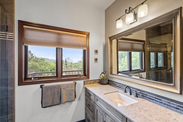 bathroom with vanity and tiled shower