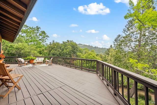 deck featuring an outdoor living space and a forest view