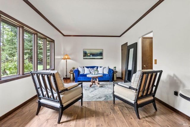 living area with crown molding, wood finished floors, and baseboards