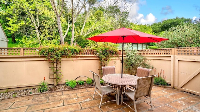 view of patio featuring fence and outdoor dining area