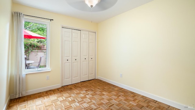 unfurnished bedroom with baseboards, ceiling fan, and a closet