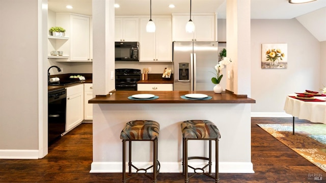 kitchen featuring open shelves, a kitchen bar, white cabinetry, a sink, and black appliances