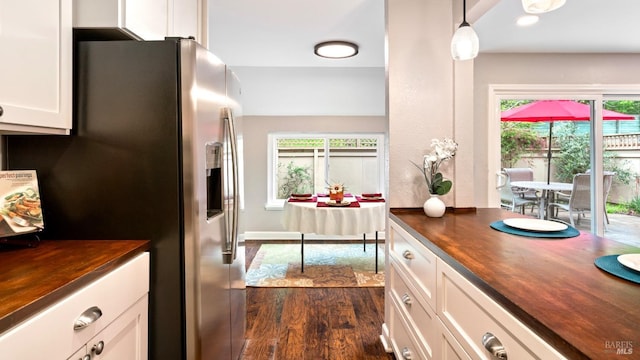kitchen featuring dark wood finished floors, stainless steel refrigerator with ice dispenser, butcher block counters, and a healthy amount of sunlight