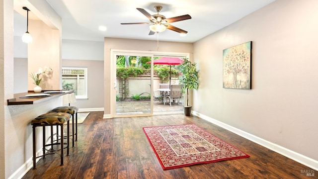 doorway to outside featuring baseboards, ceiling fan, and wood finished floors