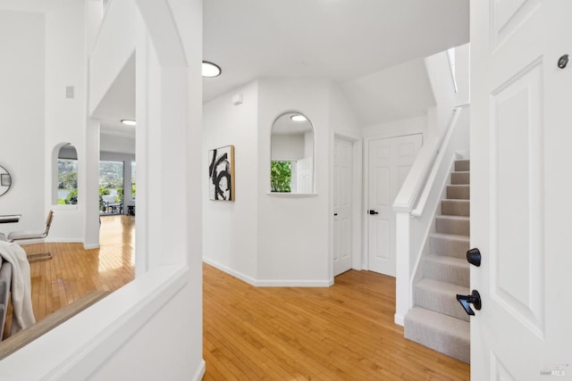 interior space with light wood-type flooring, baseboards, and stairway