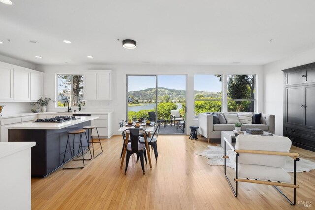 living room with recessed lighting, light wood-style floors, and a healthy amount of sunlight