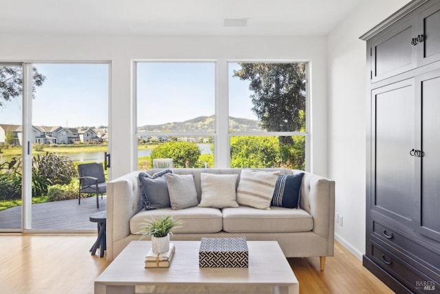 sunroom featuring a healthy amount of sunlight and a water view