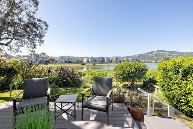 wooden terrace featuring a water and mountain view and a residential view