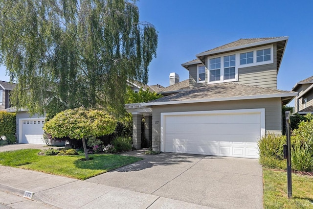 view of front of home featuring concrete driveway, a front yard, and a garage
