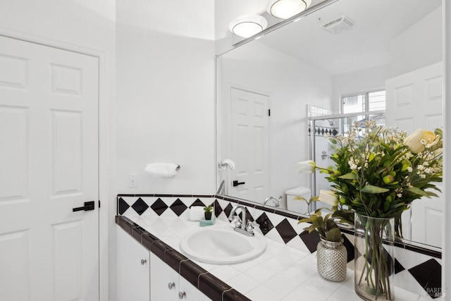 bathroom featuring backsplash, visible vents, and vanity