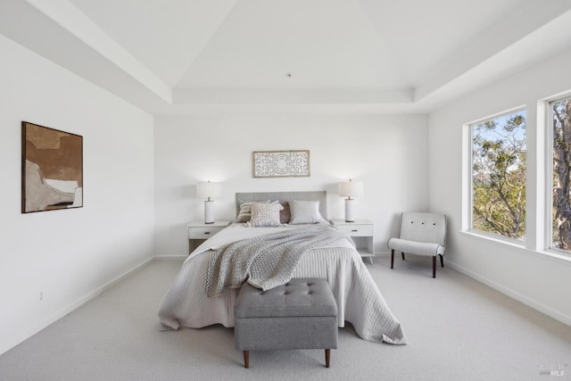 carpeted bedroom with a tray ceiling, lofted ceiling, and baseboards