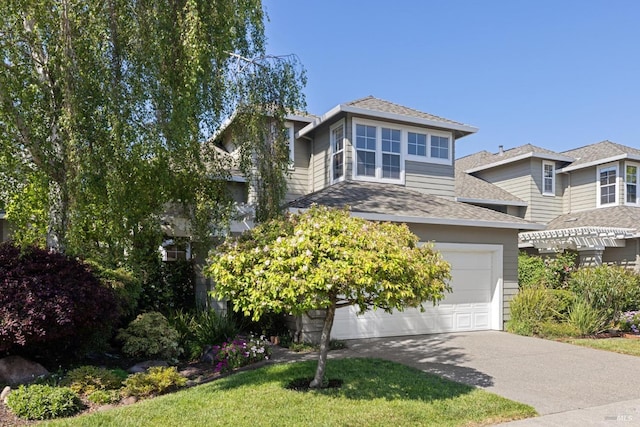 view of front of house with a garage, driveway, and a shingled roof
