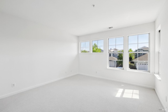 spare room with baseboards, carpet flooring, and visible vents