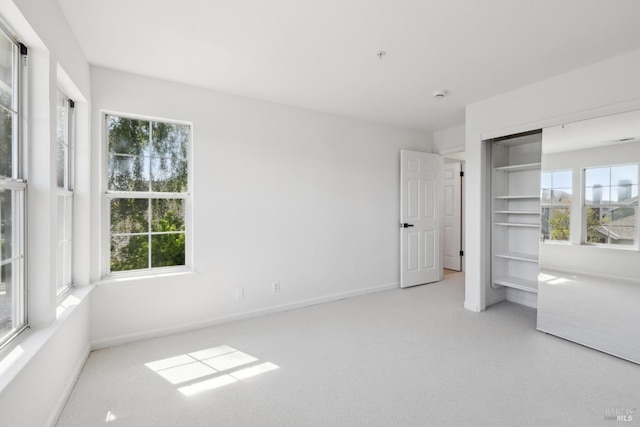 unfurnished bedroom with baseboards, carpet, and a closet