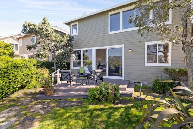 rear view of property featuring a wooden deck, a yard, and crawl space