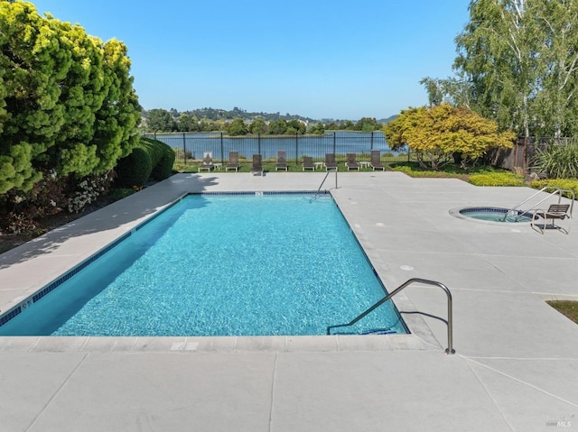 pool with a fenced backyard, a community hot tub, and a patio area