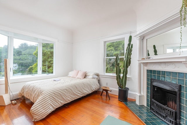55 Sunshine Ave, Sausalito, CA 94965 - bedroom featuring a tiled fireplace, hardwood / wood-style flooring, and baseboards