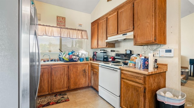 kitchen featuring light countertops, freestanding refrigerator, electric stove, and under cabinet range hood