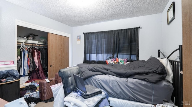 carpeted bedroom with a textured ceiling and a closet