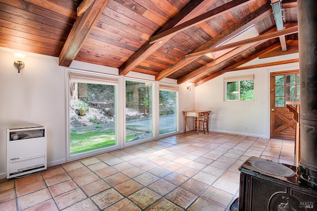 interior space with baseboards, wooden ceiling, lofted ceiling with beams, heating unit, and tile patterned floors